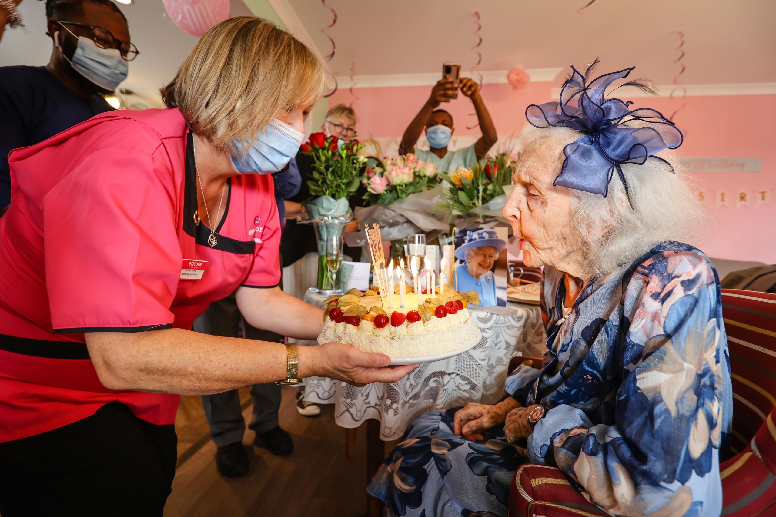 Fairmile Grange resident blowing out candles on her birthday cake for her 100th birthday
