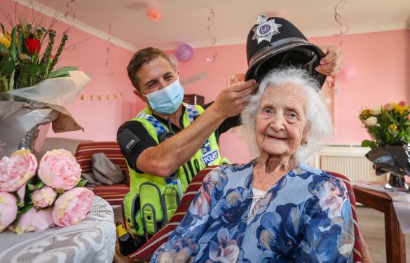 Fairmile Grange Care Home resident celebrating her 100th birthday with a Dorset police officer 