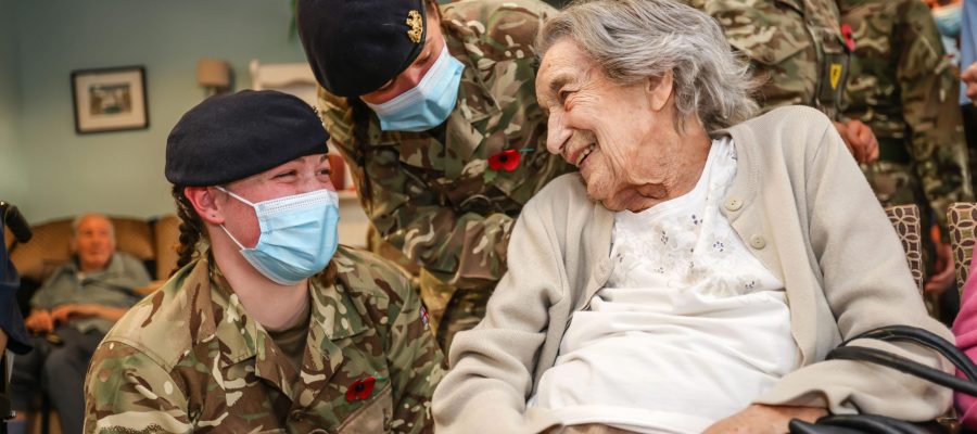 Army recruits smiling with Hamble Heights care home resident
