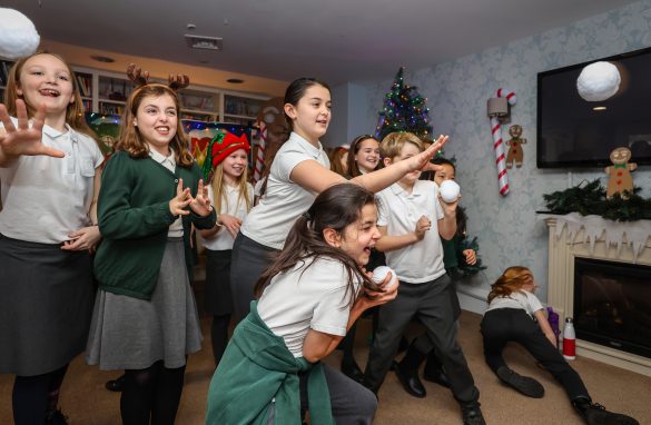 Whiteley Primary School pupils smiling while throwing snowballs at Hamble Heights Care Home